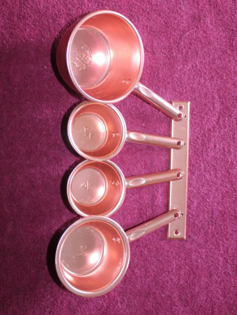 4-piece copper colored metal  measuring cups, complete with a matching hanger